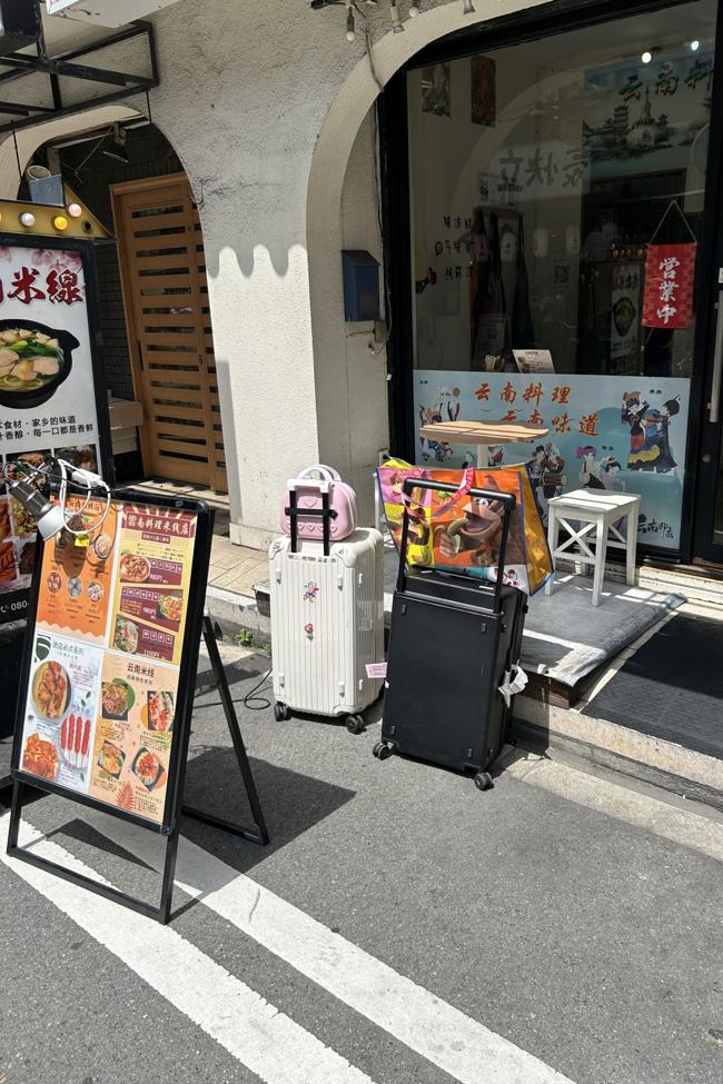 Maletas en la calle mientras los comensales están dentro comiendo