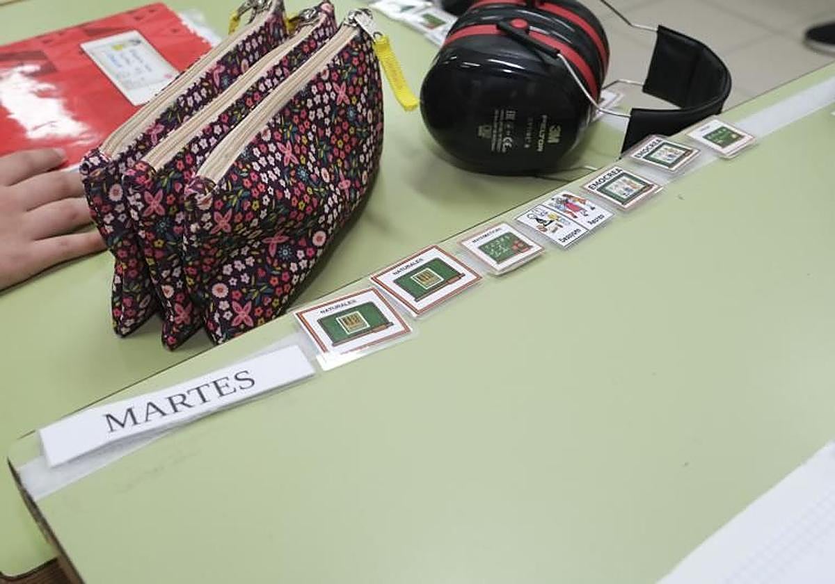 Pictogramas de la agenda escolar y auriculares para un estudiante con TEA en un centro escolar.