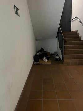 Imagen de una de las personas que duerme junto a la escalera del aparcamiento de los Nuevos Juzgados.