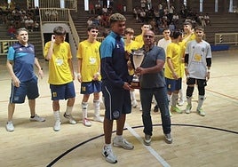 El presidente del Comité de Fútbol Sala de la FIFLP le entrega la copa de 'campeón' al Agüimes cadete.