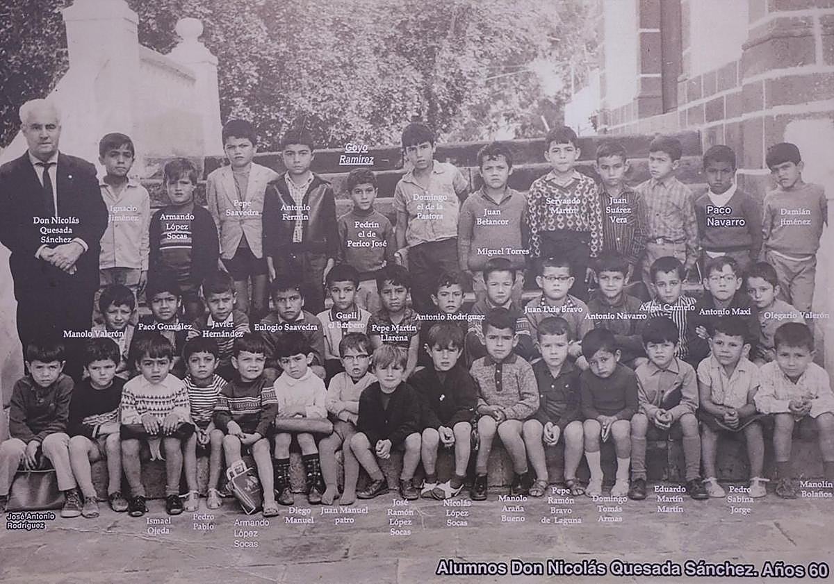 Imagen principal - Arriba, el maestro Nicolás Quesada, a la izquierda, junto a sus alumnos. Muy cerca de él, en segunda fila, Paco González, exalcalde de Mogán. Debajo, alumnado en Tauro. Algunos de los chiquillos posaron descalzos. Al lado, la edil Díaz mirando uno de los álbumes cedidos para la muestra por la maestra ya jubilada Inmaculada Rodríguez.