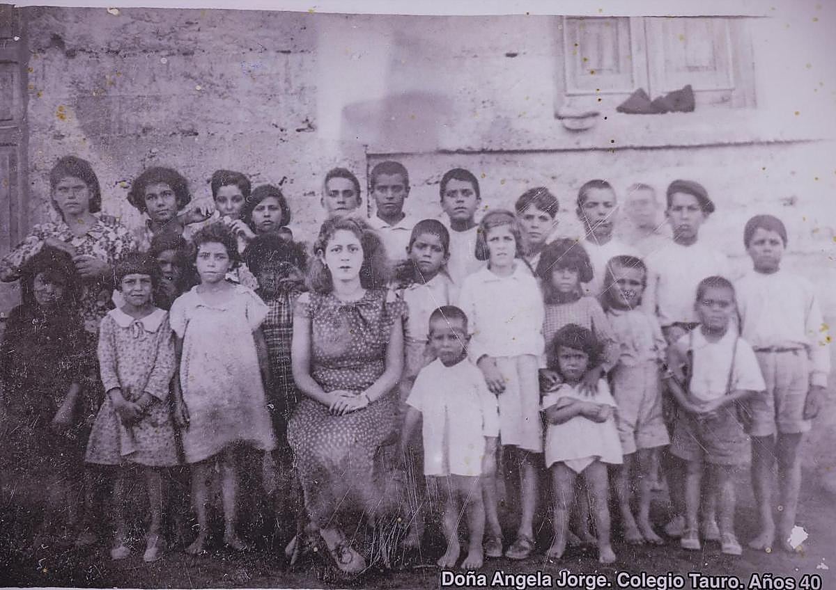 Imagen secundaria 1 - Arriba, el maestro Nicolás Quesada, a la izquierda, junto a sus alumnos. Muy cerca de él, en segunda fila, Paco González, exalcalde de Mogán. Debajo, alumnado en Tauro. Algunos de los chiquillos posaron descalzos. Al lado, la edil Díaz mirando uno de los álbumes cedidos para la muestra por la maestra ya jubilada Inmaculada Rodríguez.