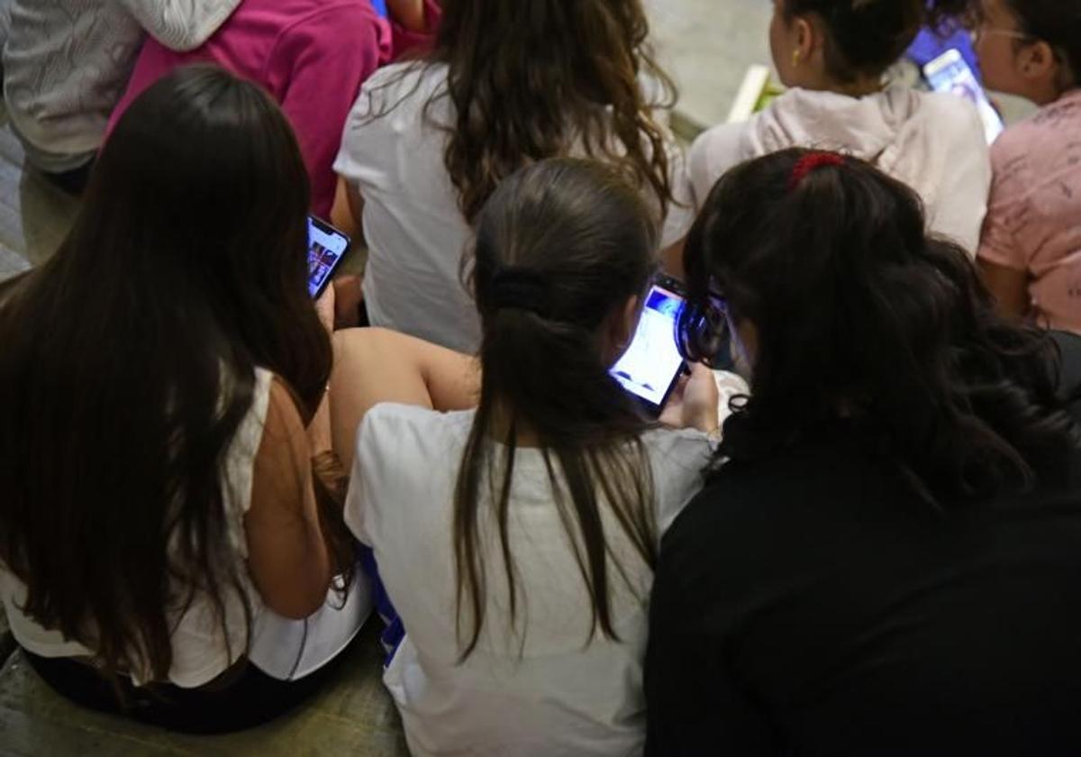 Jóvenes inmersas en sus dispositivos móviles.