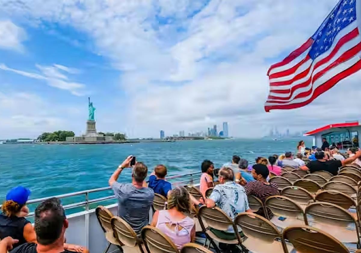 Turistas fotografiando la Estatua de la Libertad en Nueva York.