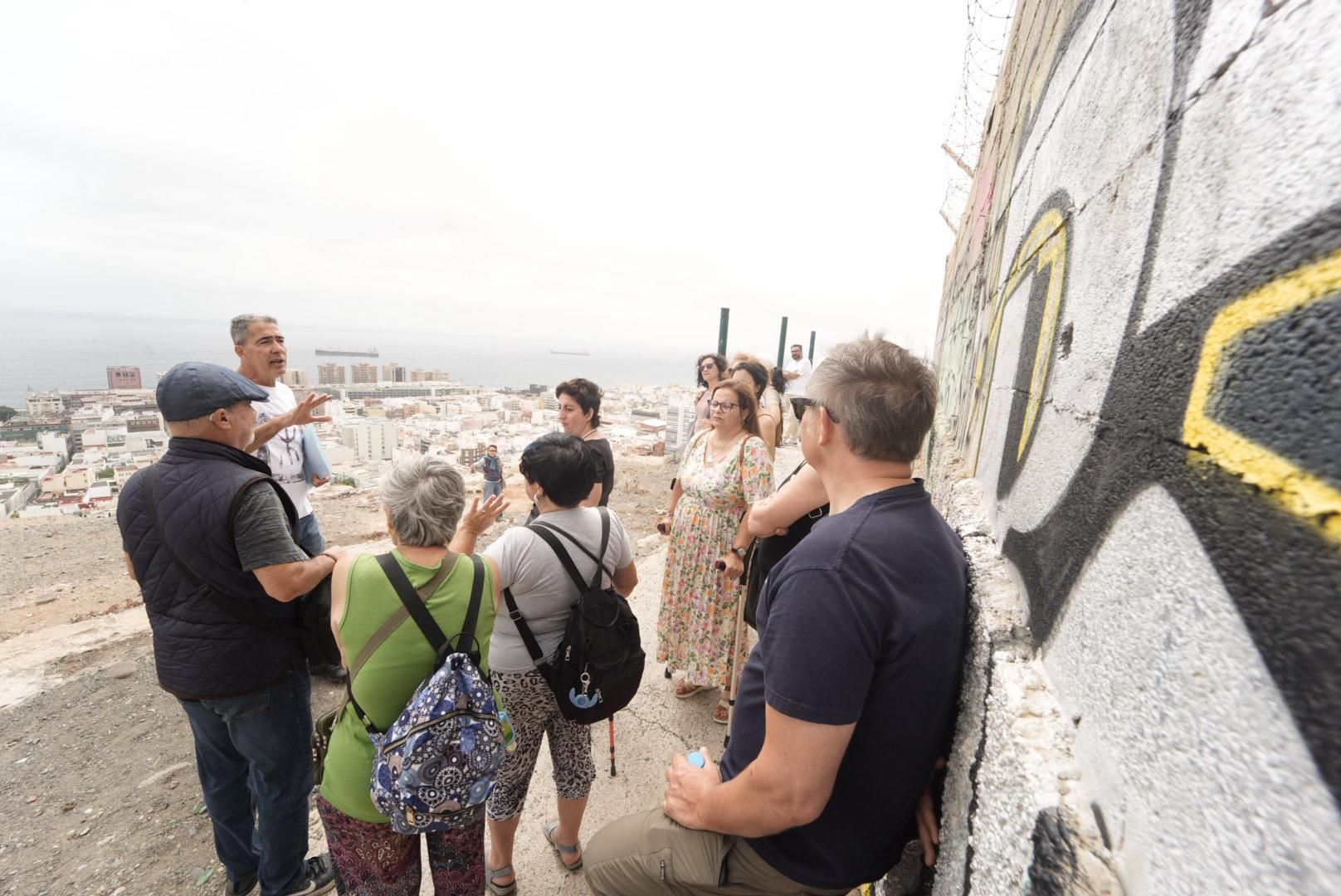 Tana Suárez explica a participantes en la ruta la historia del mirador de la Punta del Diamante.