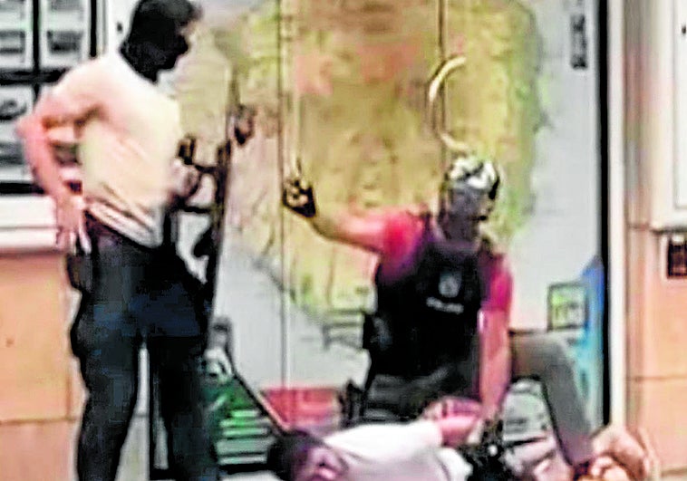 Dos agentes, junto a uno de los detenidos el sábado en la calle Presidente Alvear.