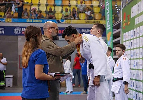 Aridany Romero entrega una medalla a un joven judoka en el Arena.