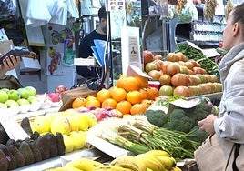 Compras en un puesto de un mercado de frutas y verduras.