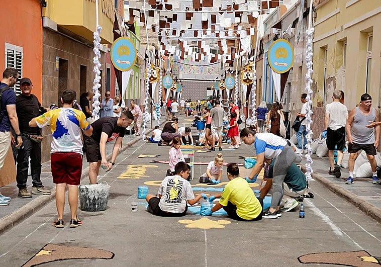 Los vecinos trabajan en la elaboración de una alfombra en la calle Menceyes.