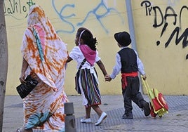 Una mujer lleva al colegio a sus dos hijos en la celebración del Día de Canarias.