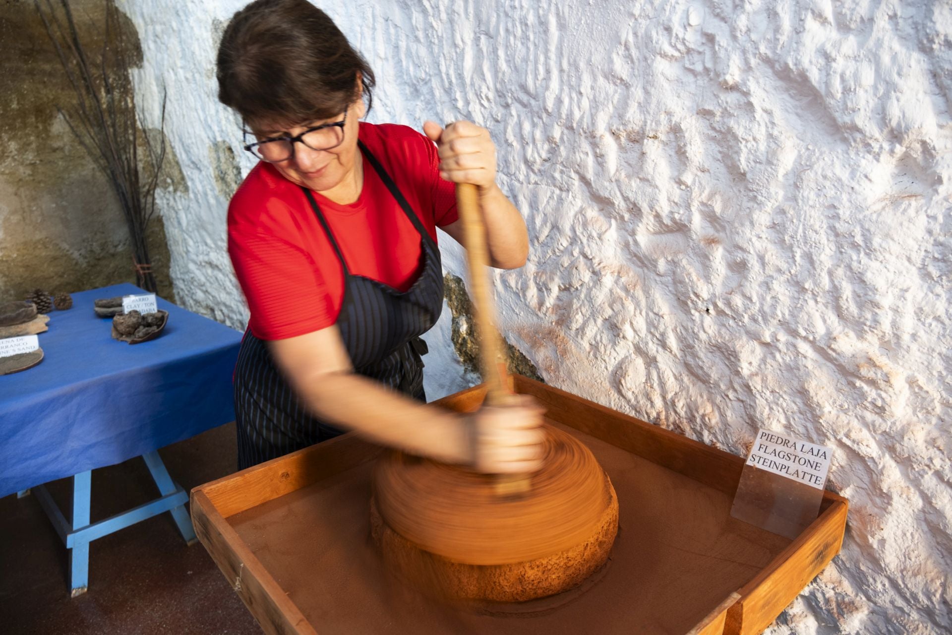 María León muele el almagre en un molino tradicional.