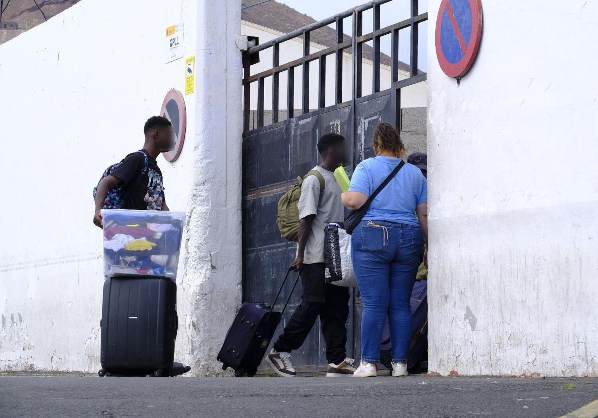 Dos menores junto a la trabajadora que los acompaña a ingresar al Canarias 50 en la tarde de este miércoles.