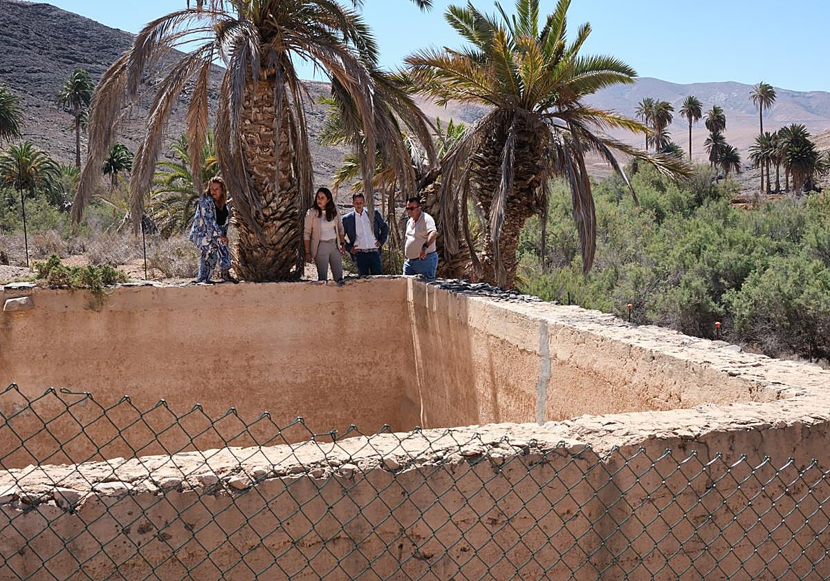 Imagen principal - La presidenta insular, el alcalde de Pájara y el concejal del Sector Primario, en el tanque grande de la Finca de Ajuy.