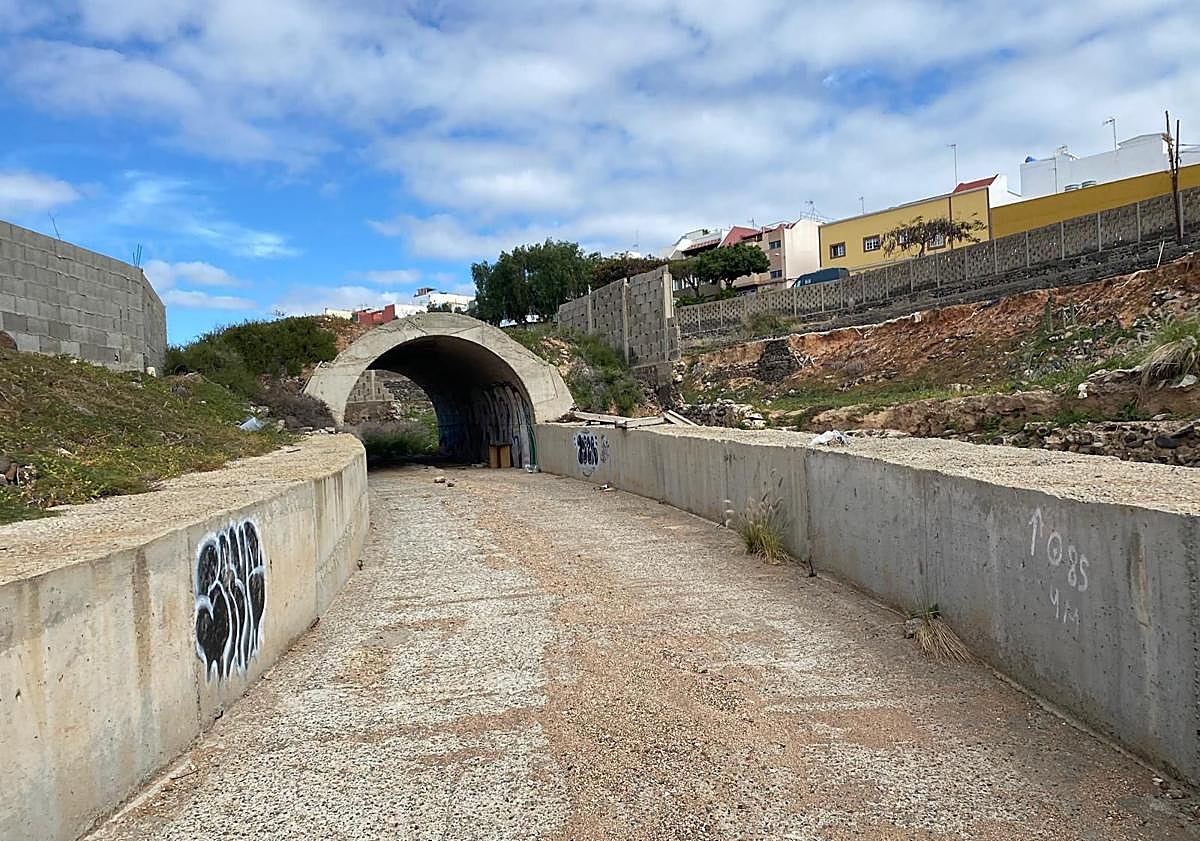 Imagen principal - En la foto superior, canalización del barranco de Sacateclas saliendo de Las Huesas, y en la foto inferior izquierda, embudo por el que pretenden que se metan sus aguas. La consecuencia se observa en la tercera imagen. La escorrentía usó la GC-117 bajo la GC-1 como canal de paso. La mancha del barro deja ver hasta qué altura llegó. 