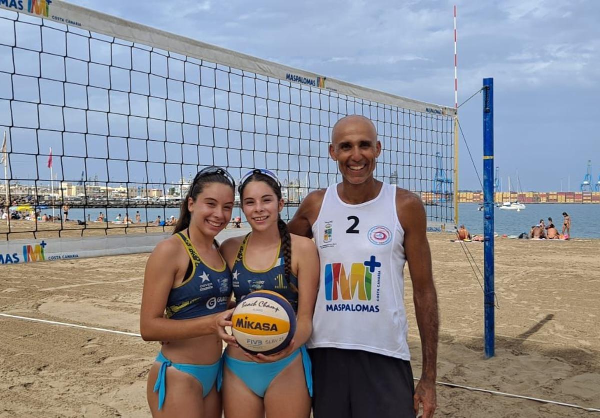 Olga y Alicia Romero Postigo posan con su entrenador Pablo Bautista Pérez en la Playa de Las Alcaravaneras.