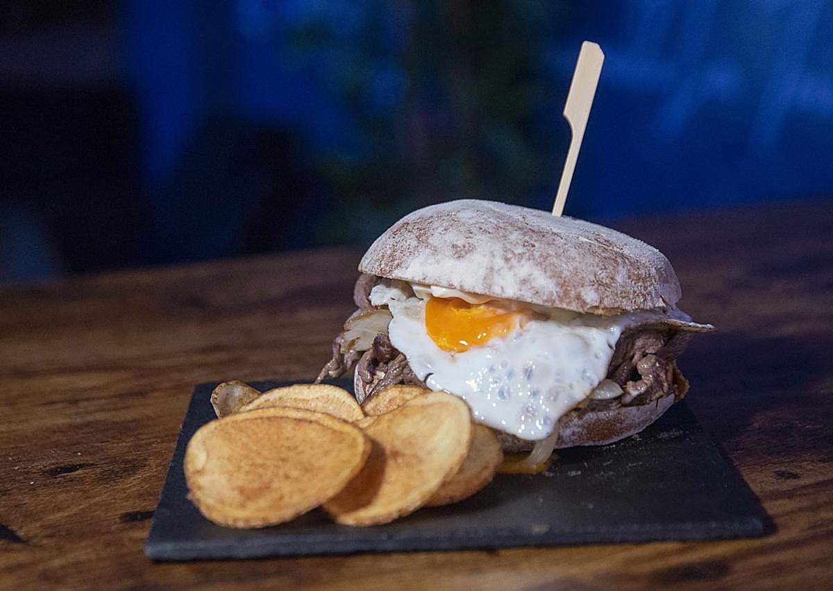 Imagen secundaria 1 - Arriba, cóctel Km0 y una de las variedades de churrasco. Debajo, Guillermo, Camila y Aaron, uno de los trabajadores del local.