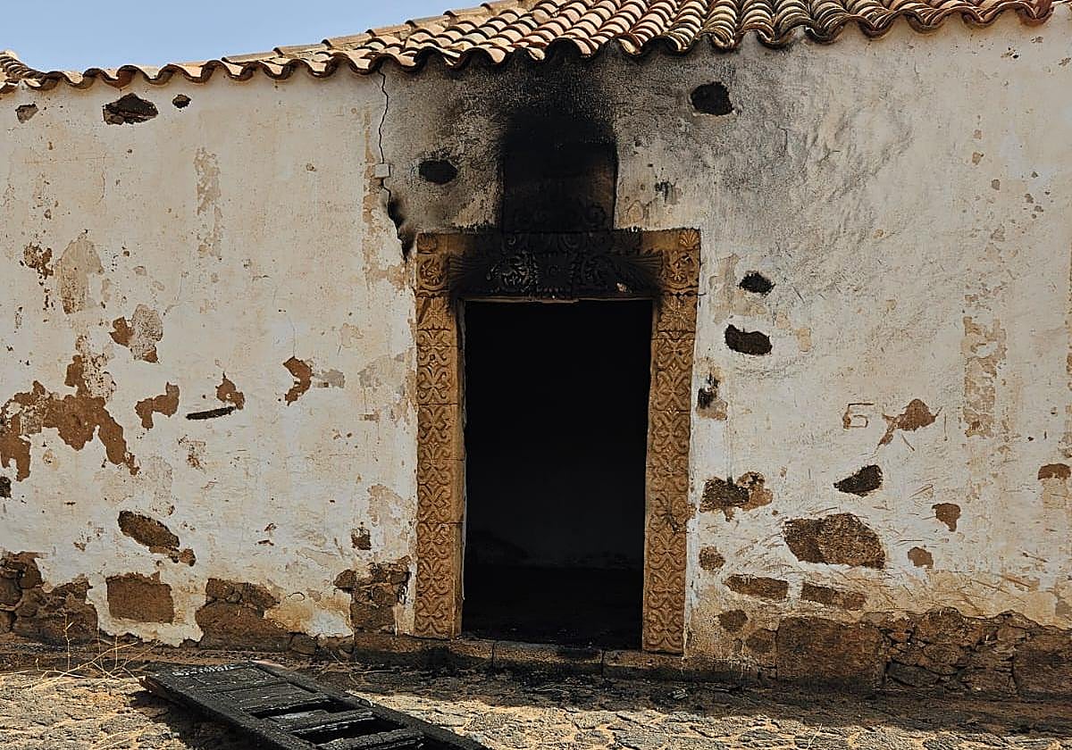 El fuego hizo estragos en la portada de piedra blanca labrada de la ermita situada en La Oliva, acabando con la cruz tallada central.