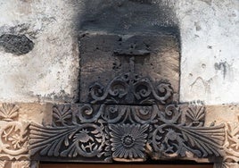 Detalle del dintel de la portada de la ermita de Puerto Escondido o la Capellanía, en La Oliva, con la cruz y las decoraciones vegetales y de aves quemadas.