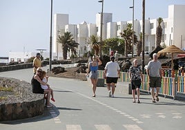 Turistas disfrutando de un paseo por un espacio de primera línea en Costa Teguise.