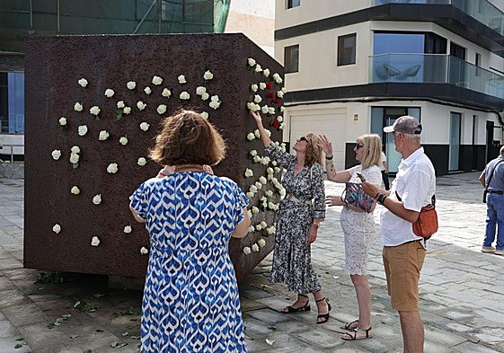 Familiares realizando la ofrenda en el Monumento El Cubo, en Las Palmas de Gran Canaria.