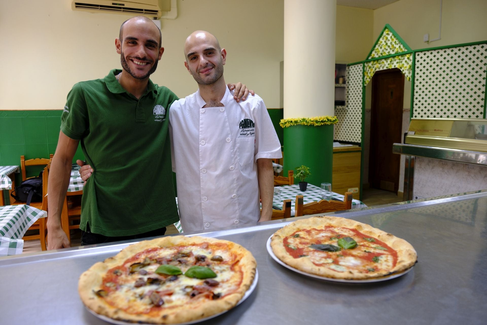 Luca (izquierda) y Mattia (derecha) junto a dos de las pizzas sin gluten de su carta.