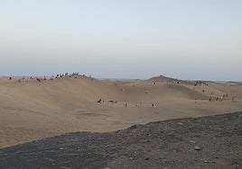 Imagen de personas saltándose las normas de seguridad y caminando sobre las dunas de Maspalomas.