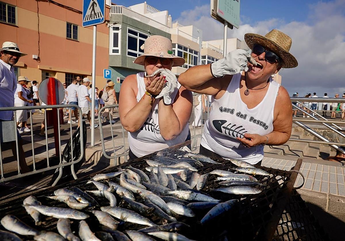 Dos personas cocinando sardinas en La Vará.