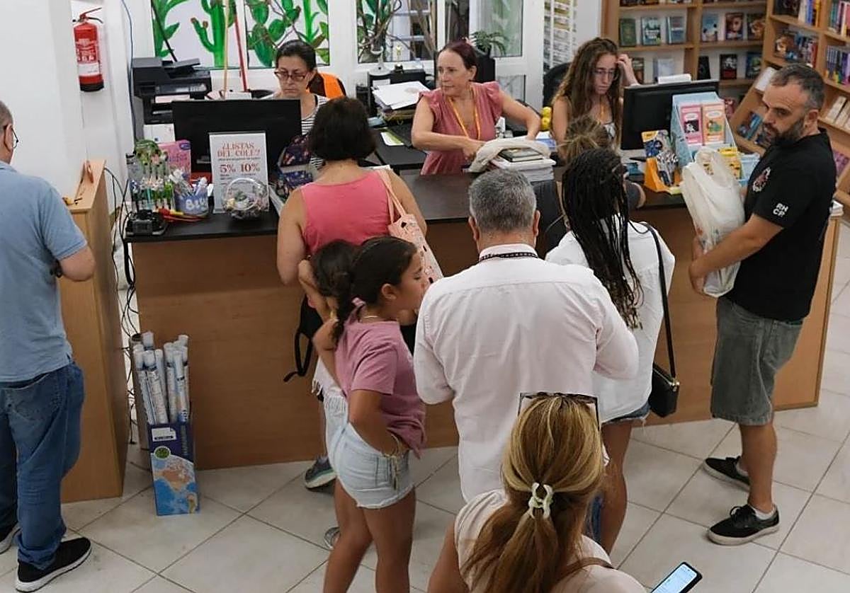 Padres comprando material para sus hijos.