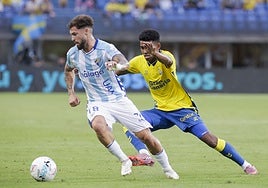 Marvin golpea el balón ante la mirada de un jugador del Málaga.