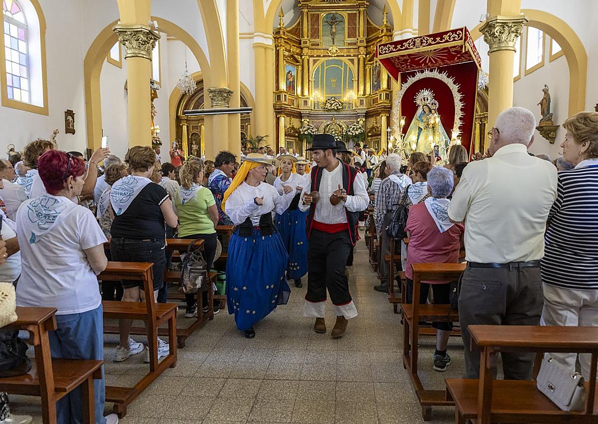 Imagen secundaria 1 - Almuerzo popular tras la misa. grupo folclórico dentro del templo y peregrinación de varias imágenes con el Roque Bentayga de fondo.