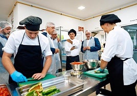 Manuel Domónguez, Poli Suárez y el alcalde de Guía junto a estudiantes de Cocina del CIFP Santa María de Guía este lunes.