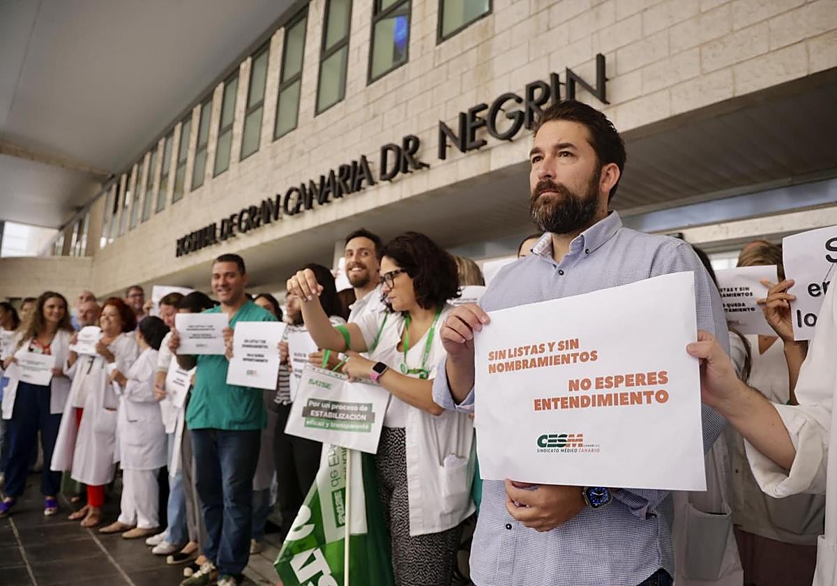 Éric Álvarez, a la derecha, junto a otros médicos protestando a las puertas del hospital Doctor Negrín.