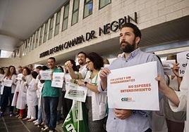Éric Álvarez, a la derecha, junto a otros médicos protestando a las puertas del hospital Doctor Negrín.