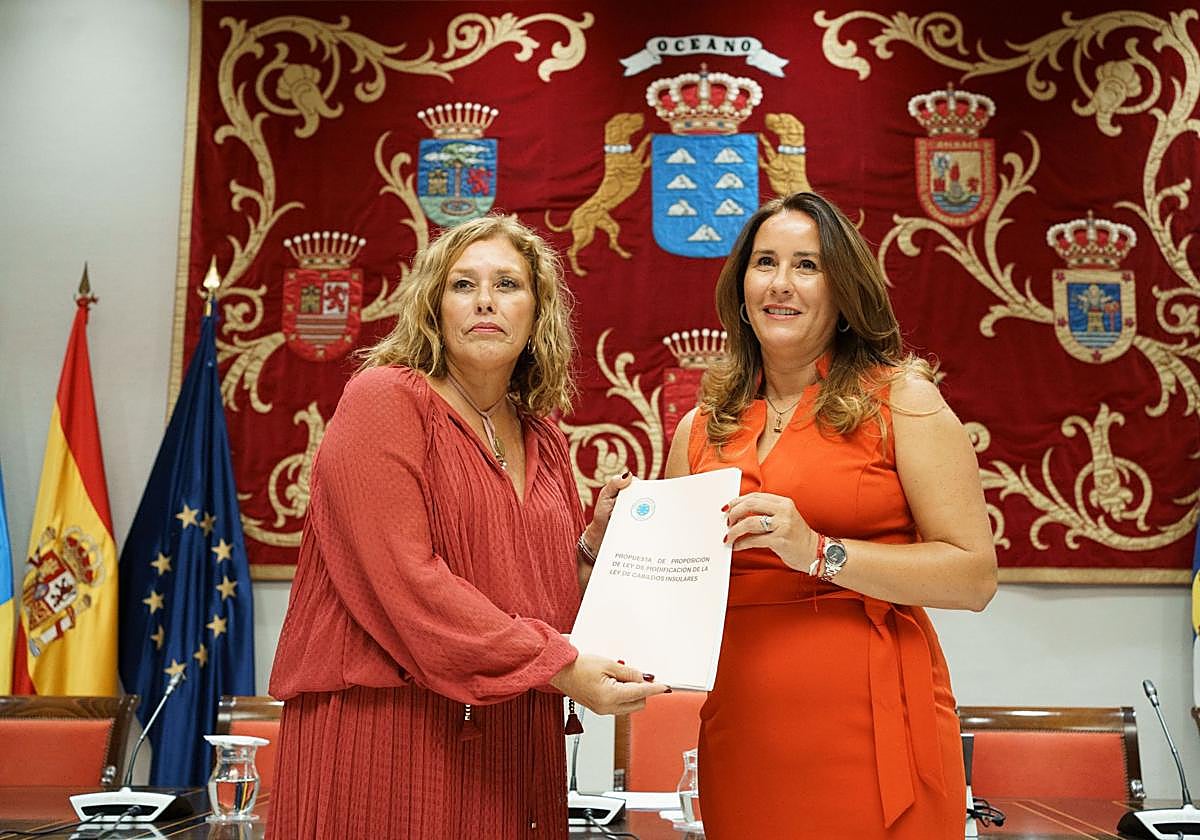 La presidenta del Cabildo de Fuerteventura y presidenta de la Federación Canaria de Islas (FECAI), Lola García hace entrega de la propuesta de ley de Cabildos Insulares a la presidenta del Parlamento de Canarias, Astrid Pérez.
