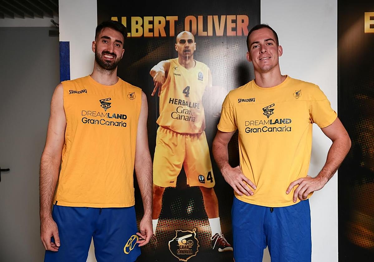 Eric Vila y Miqui Salvó posan para CANARIAS7 delante de la fotografía de Albert Oliver que se encuentra en los vestuarios del Gran Canaria Arena.