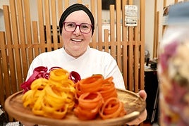Cristina, dueña de Sabor y Arte, con una bandeja de sus pastas de colores más famosas.