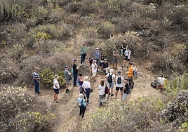Grupo de personas de una de las visitas a la Sima, a los pies de la chimenea volcánica.