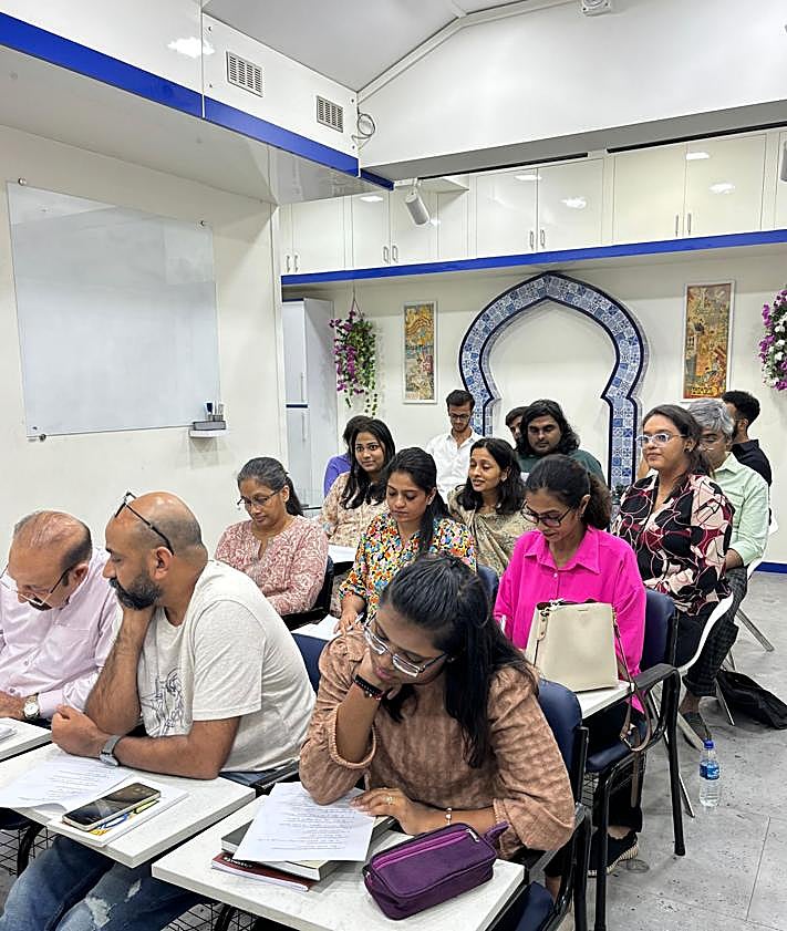 Imagen secundaria 2 - Dinesh Govindani (sentado) con un grupo de alumnos y distintos momentos de las clases. 