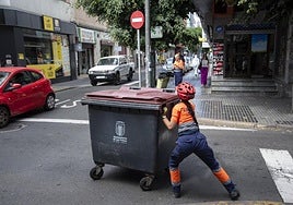 Una operaria de Recogida empuja un contenedor de basura en Las Palmas de Gran Canaria.
