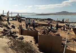 El yacimiento del taller romano de púrpura de la isla de Lobos, con la costa de Corralejo al fondo.