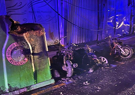 Un contenedor quemado y los restos de varias motos afectadas por el fuego.