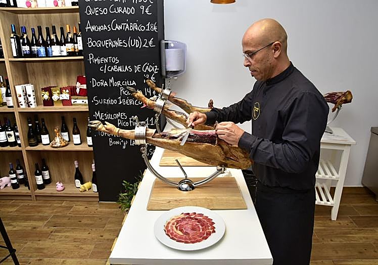 Ernesto cortando jamón.