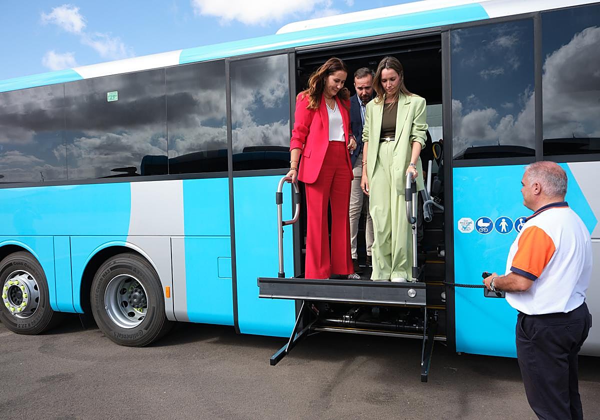 La presidenta Lola García, el consejero insular de Transportes, Luis González, y la directora general María Fernández prueban la plataforma para personas con movilidad reducida de una de las doce guaguas de estreno.