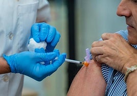 Una enfermera canaria vacuna contra la gripe a un sanitario.