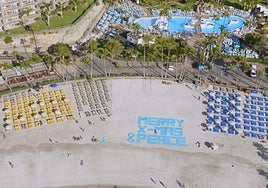 Anfi felicita la Navidad con un mensaje formado por cientos de toallas desde la playa