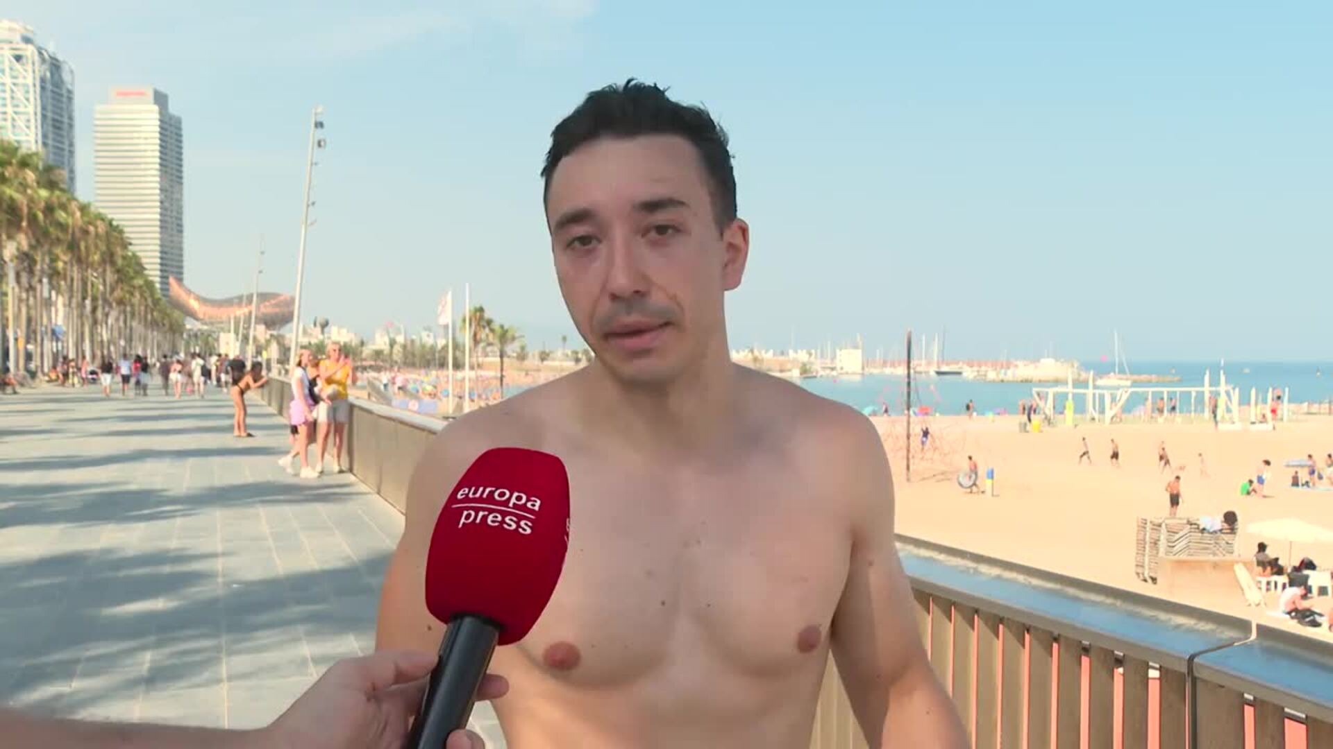 Turistas desafían la ola de calor en Barcelona bañándose en la playa y tomando precauciones