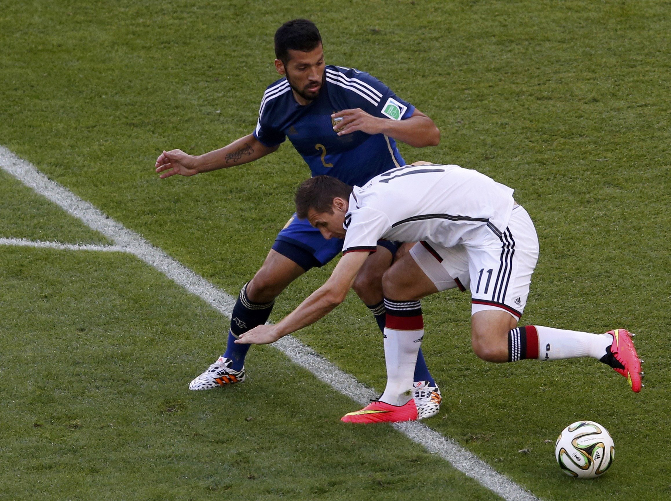 Garay (arriba) pelea un balón con Klose.