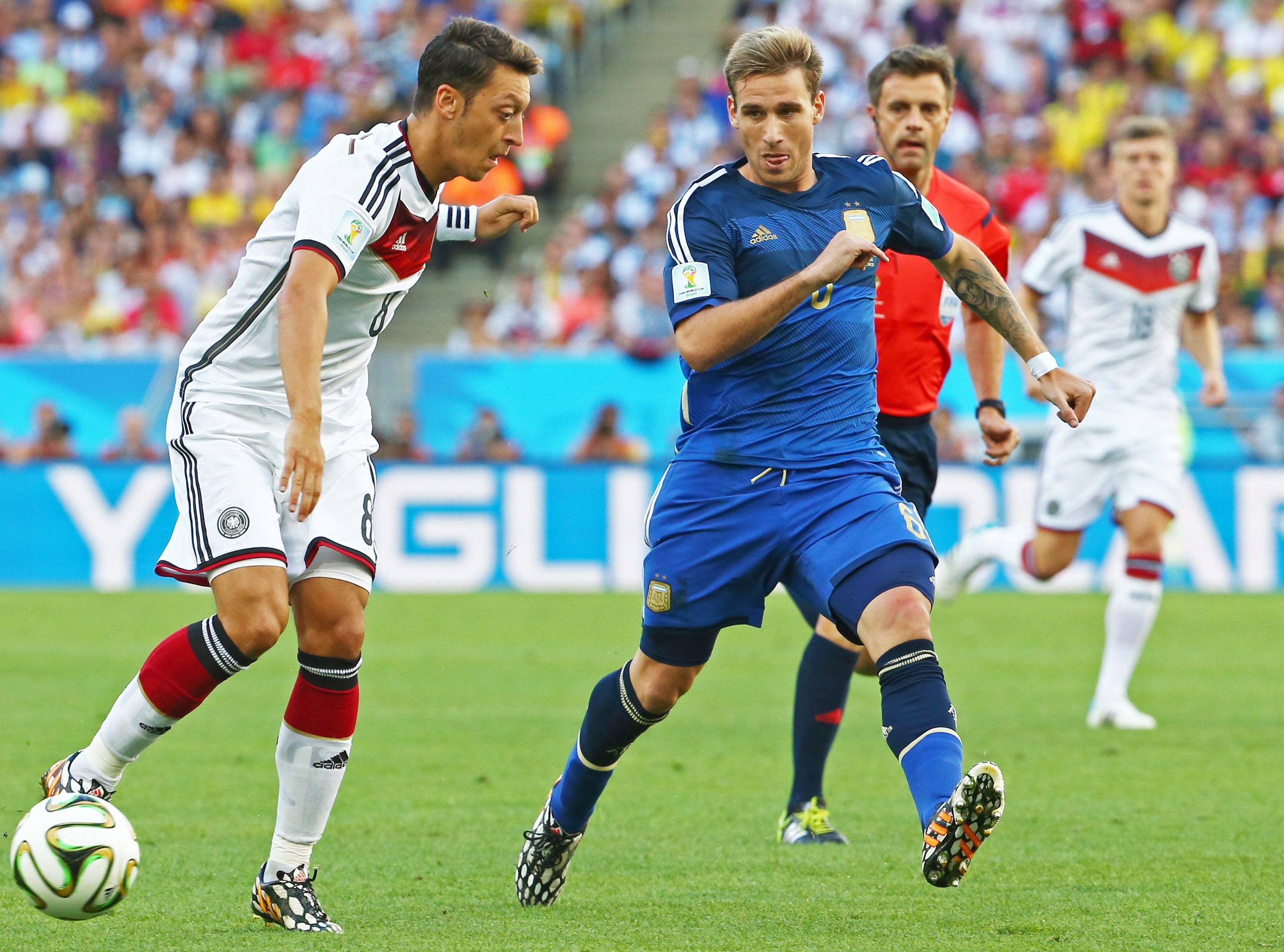 Özil controla un balón ante Biglia.