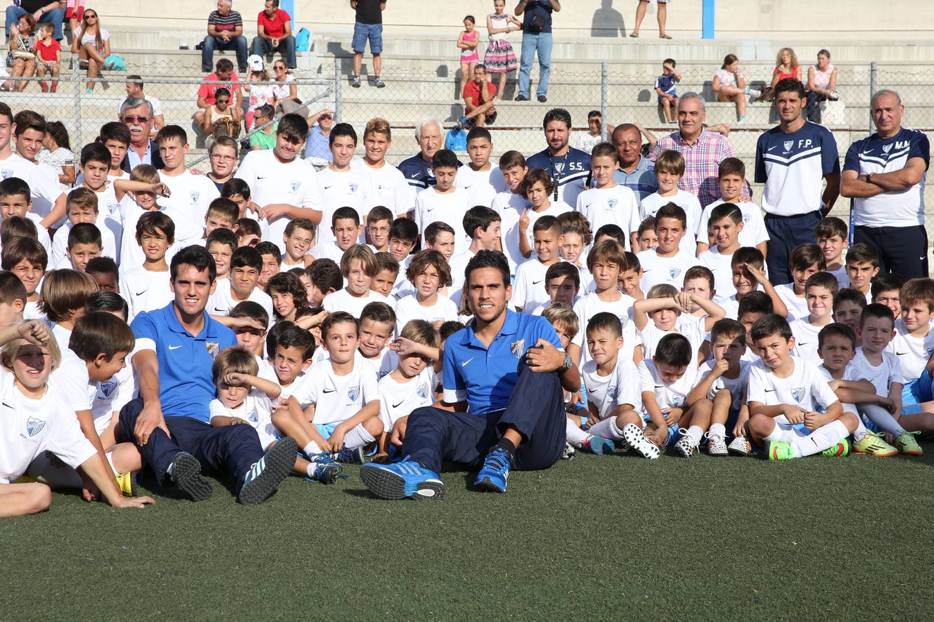 Jugadores y niños en las escuelas deportivas del Málaga.