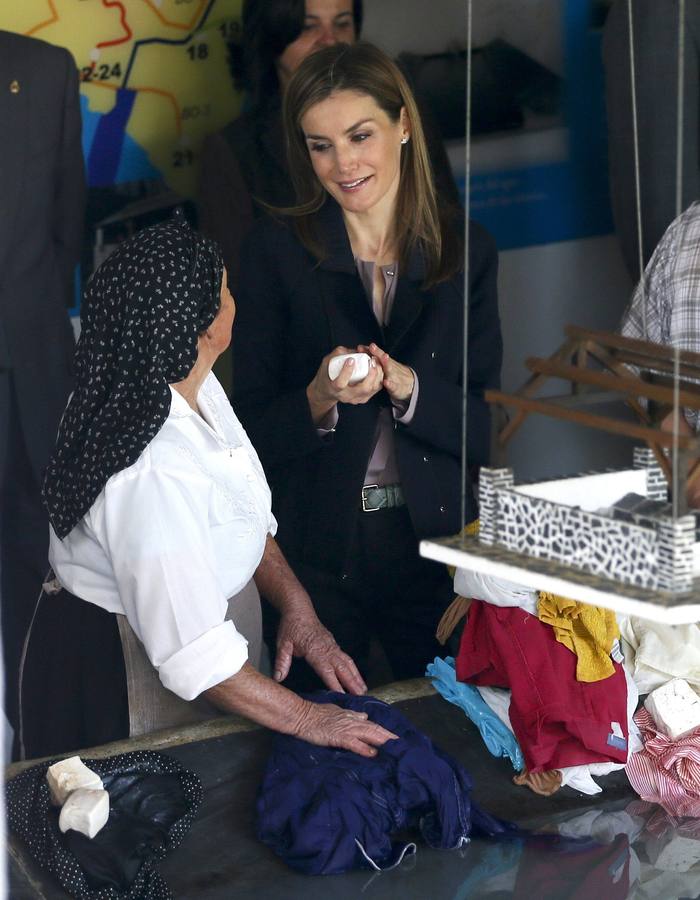 La reina Letizia conversa con una mujer en un antiguo lavadero de Boal.